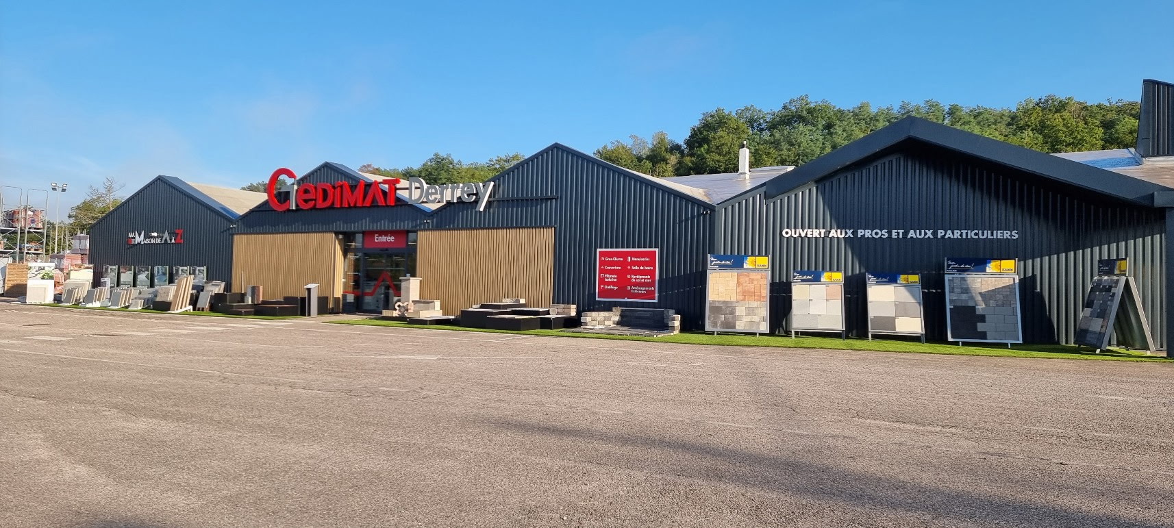 Fa�ade du magasin Gedimat Derrey � Poussay, avec l’espace d’exposition de mat�riaux et rev�tements ext�rieurs devant le b�timent.
